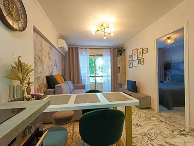 a kitchen and living room with a table and chairs at La Résidence Fleuries - Plage in Cannes