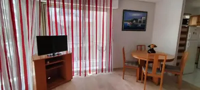a living room with a television and a table with chairs at T3 spacious 60 m near the beach of Cannes in Cannes