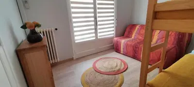 a small room with a bunk bed and a chair at T3 spacious 60 m near the beach of Cannes in Cannes
