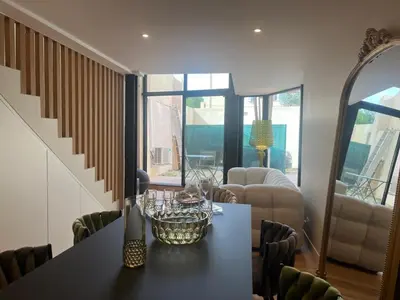 a dining room with a table and a living room at Nice Living Cannes Plage in Cannes