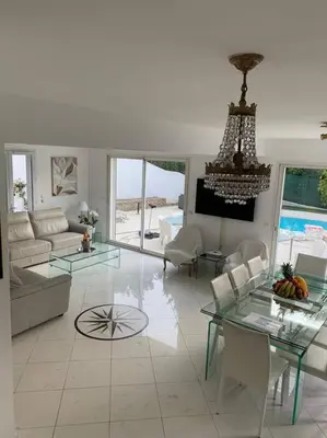 a living room with a glass table and a chandelier at Cannes centre Villa piscine spa in Cannes