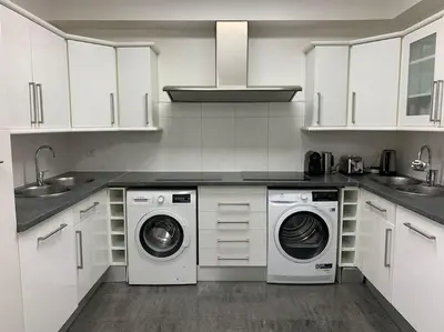 a kitchen with white cabinets and a washer and dryer at Cannes centre Villa piscine spa in Cannes