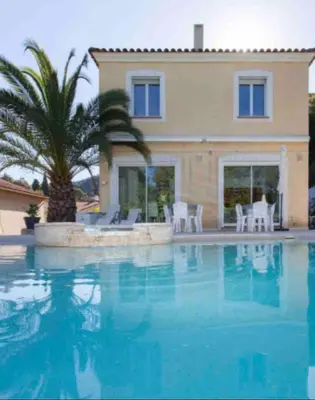 a house with a palm tree and a swimming pool at Cannes centre Villa piscine spa in Cannes