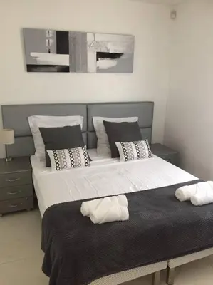 a bedroom with a large bed with white sheets and pillows at Cannes centre Villa piscine spa in Cannes