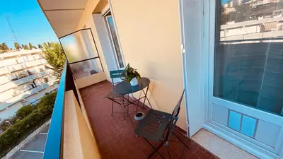 an apartment balcony with a chair and a window at Joli 3pièces refait à neuf et très bien situé in Cannes