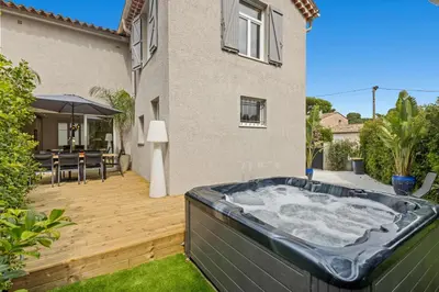 a hot tub in a backyard with a house at Luxueuse Villa L'Olivier Cannes 4 chambres jacuzzi in Cannes