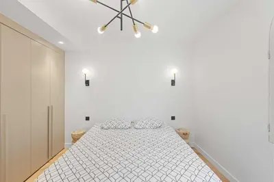 a white bedroom with a bed and a chandelier at Luxueuse Villa L'Olivier Cannes 4 chambres jacuzzi in Cannes