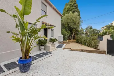 a plant in a blue pot next to a house at Luxueuse Villa L'Olivier Cannes 4 chambres jacuzzi in Cannes