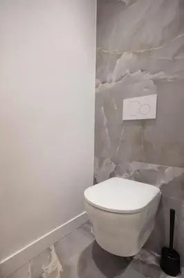 a white toilet in a bathroom with a marble wall at Luxueuse Villa L'Olivier Cannes 4 chambres jacuzzi in Cannes