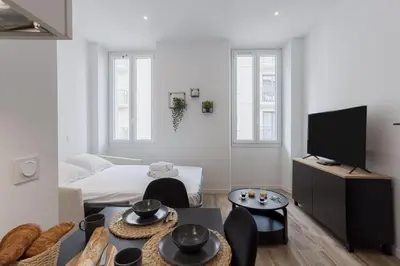 a white living room with a bed and a tv at 