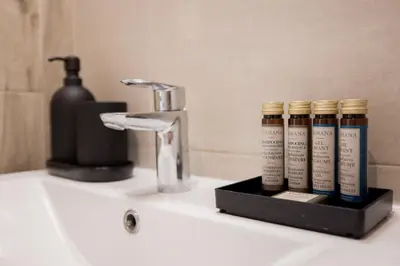 a bathroom sink with four bottles of hair products at 