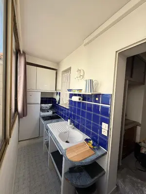 a small kitchen with a sink and blue tiles at Palm Beach Escape in Cannes
