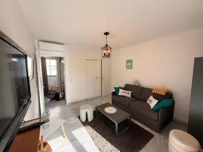 a living room with a couch and a tv at Palm Beach Escape in Cannes