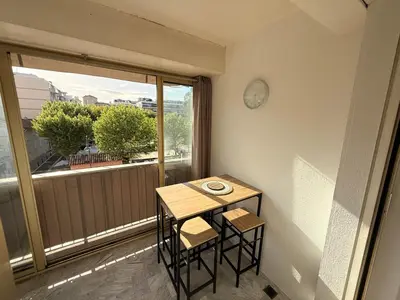 a small table and chairs in a room with a window at Palm Beach Escape in Cannes