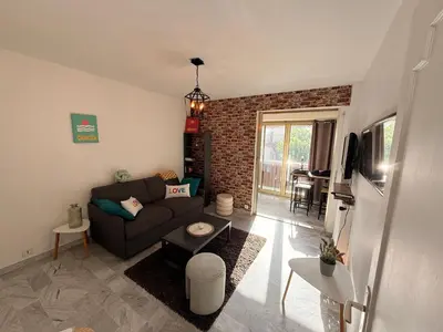 a living room with a couch and a brick wall at Palm Beach Escape in Cannes