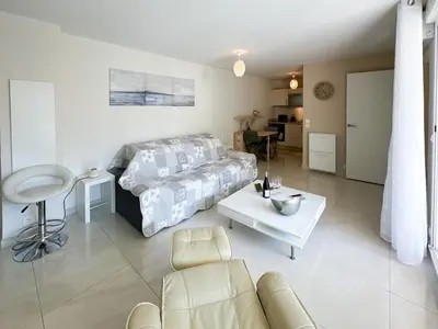 a living room with a bed and a table at PDA4 - 2 pièces avec terrasse in Cannes