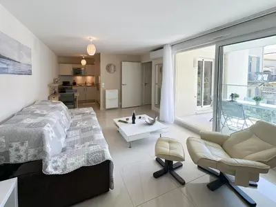 a bedroom with a large bed and a living room at PDA4 - 2 pièces avec terrasse in Cannes