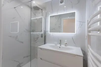 a white bathroom with a sink and a shower at 7 Pradignac by Halldis in Cannes