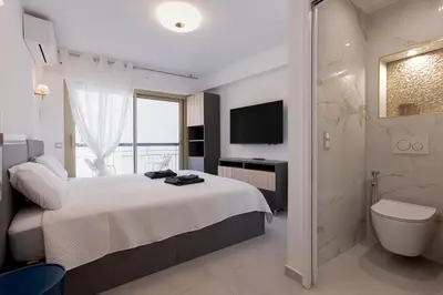 a bedroom with a bed and a bathroom with a shower at 7 Pradignac by Halldis in Cannes