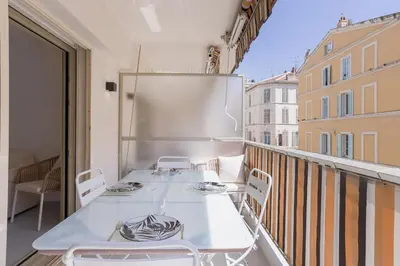 a balcony with a white table and chairs on it at 7 Pradignac by Halldis in Cannes
