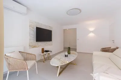 a living room with a white couch and a table at 7 Pradignac by Halldis in Cannes