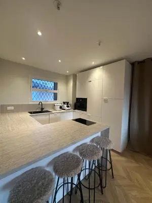 a kitchen with two bar stools and a counter top at Spacieux et Moderne T2 près du centre in Cannes