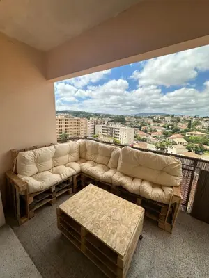 a living room with a couch and a large window at Spacieux et Moderne T2 près du centre in Cannes
