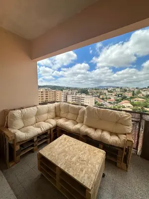 a living room with a couch and a large window at Spacieux et Moderne T2 près du centre in Cannes