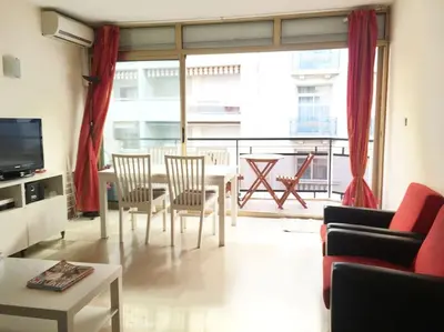 a living room with a table and chairs and a large window at Cannes 2pièces Croisette Martinez in Cannes
