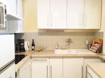 a kitchen with white cabinets and a sink at Cannes 2pièces Croisette Martinez in Cannes
