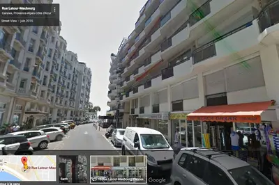 a city street with cars parked next to tall buildings at Cannes 2pièces Croisette Martinez in Cannes