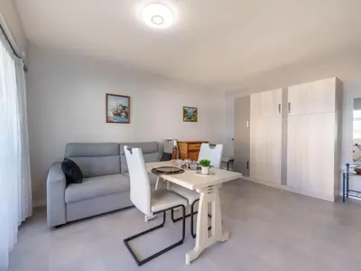 a living room with a table and a couch at Apartment Le Copacabana by Interhome in Cannes