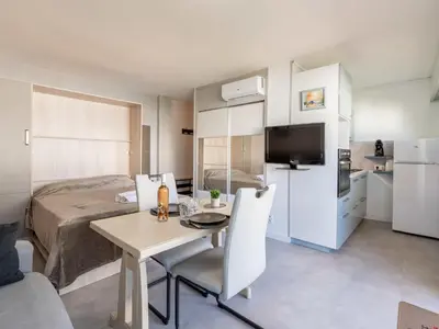 a small room with a bed and a table and chairs at Apartment Le Copacabana by Interhome in Cannes