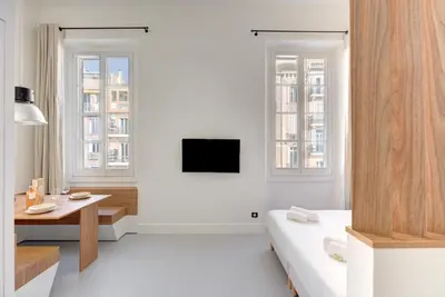 a white room with a bed and a table at Immogroom - 2 min du palais - Studio - Luxury - AC in Cannes