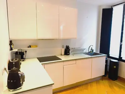 a kitchen with white cabinets and a counter top at Design Appartment 100sqm close to Palais Beach and Restaurants in Cannes
