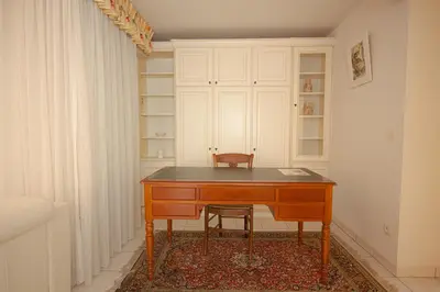 a desk in a room with a chair and a cabinet at Le Palazzio by Connexion in Cannes