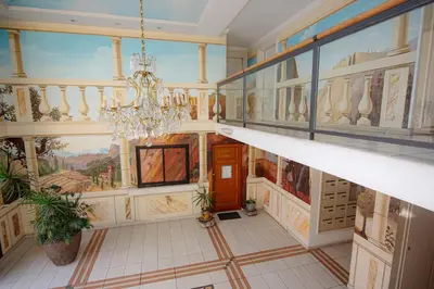 a hallway with paintings on the walls and a chandelier at Le Palazzio by Connexion in Cannes
