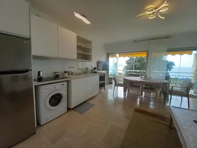 a kitchen with a washing machine and a dining room at Studio with sea view in Cannes