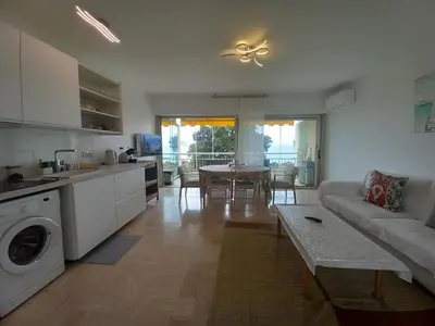 a kitchen and living room with a couch and a table at Studio with sea view in Cannes