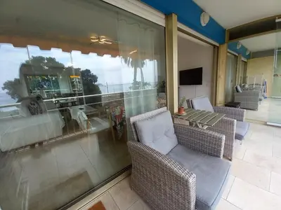 a balcony with a table and chairs and a window at Studio with sea view in Cannes