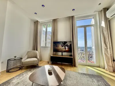 a living room with a table and a chair at charmante suite vue mer villa Carmela in Cannes