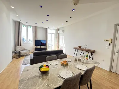 a living room with a table and chairs and a living room at charmante suite vue mer villa Carmela in Cannes