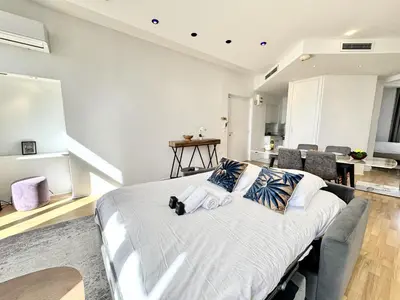 a bedroom with a large white bed with pillows at charmante suite vue mer villa Carmela in Cannes