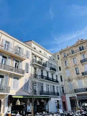 a group of buildings with tables and chairs in front of them at charmante suite vue mer villa Carmela in Cannes
