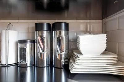 a group of silver thermos and plates on a counter at CASA RIVIERA Ecrin moderne ,tout confort, 300 m Croisette in Cannes