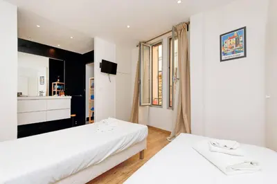 a bedroom with two beds and a television in it at CASA RIVIERA Ecrin moderne ,tout confort, 300 m Croisette in Cannes