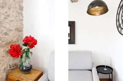 a vase with red flowers on a table next to a couch at CASA RIVIERA Ecrin moderne ,tout confort, 300 m Croisette in Cannes