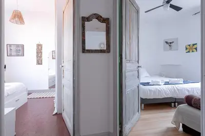 a hallway with a mirror and a bedroom with a bed at The Artists’ Retreat – Comfort in the Heart of Cannes in Cannes