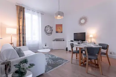 a living room with a white couch and a table at The Artists’ Retreat – Comfort in the Heart of Cannes in Cannes