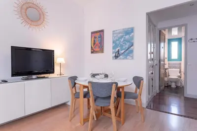 a dining room with a table with chairs and a tv at The Artists’ Retreat – Comfort in the Heart of Cannes in Cannes